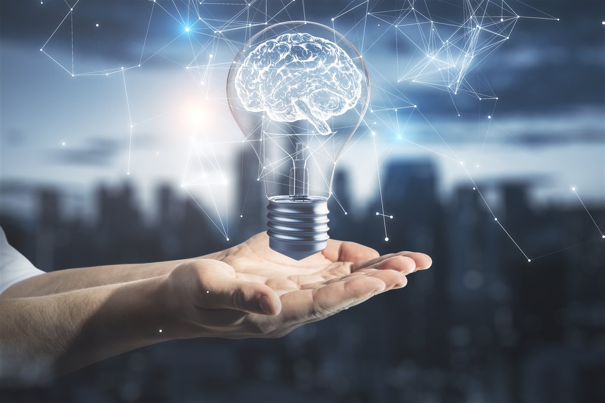 Light bulb with a brain, held in an open hand